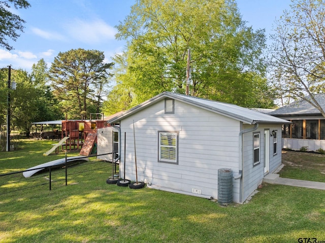 view of side of property featuring a yard, cooling unit, and a playground
