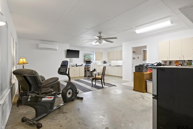 exercise room with a ceiling fan, a drop ceiling, and a wall unit AC