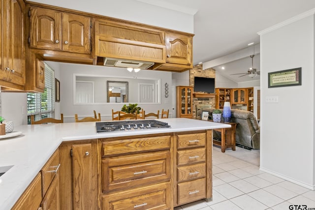 kitchen featuring a peninsula, stainless steel gas cooktop, ceiling fan, light countertops, and light tile patterned floors