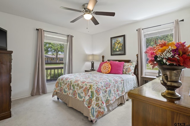 bedroom with light colored carpet, baseboards, a ceiling fan, and access to exterior