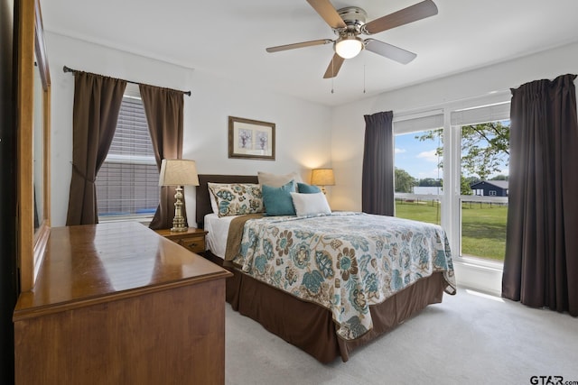 bedroom featuring light colored carpet and a ceiling fan