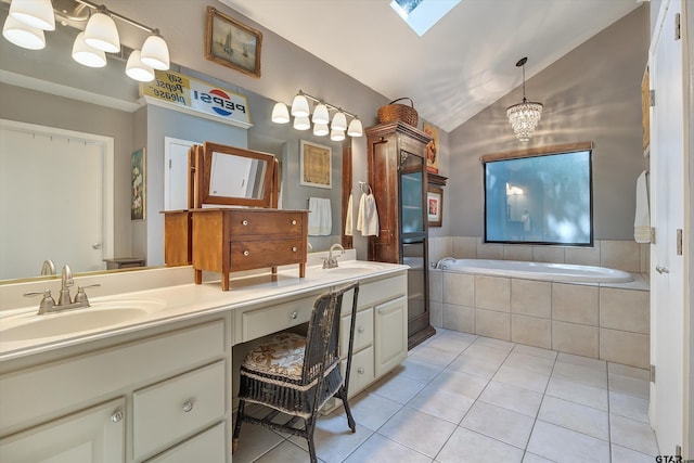 bathroom with tile patterned flooring, a chandelier, vanity, lofted ceiling with skylight, and a relaxing tiled tub