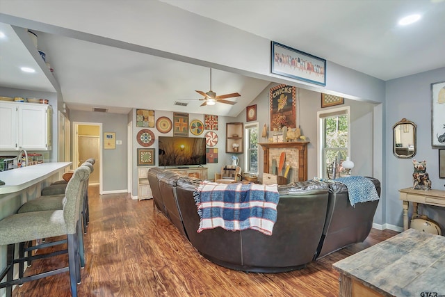 living room featuring dark hardwood / wood-style flooring, vaulted ceiling, and ceiling fan