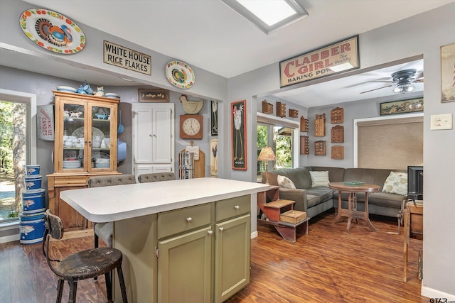 kitchen featuring hardwood / wood-style flooring, a kitchen breakfast bar, a healthy amount of sunlight, and green cabinetry