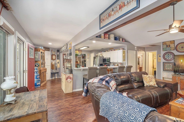 living room with dark wood-type flooring, ceiling fan, and vaulted ceiling