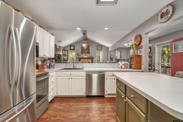 kitchen featuring dark hardwood / wood-style flooring, lofted ceiling, kitchen peninsula, sink, and appliances with stainless steel finishes