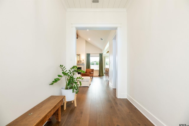 hall with lofted ceiling, crown molding, and dark wood-type flooring