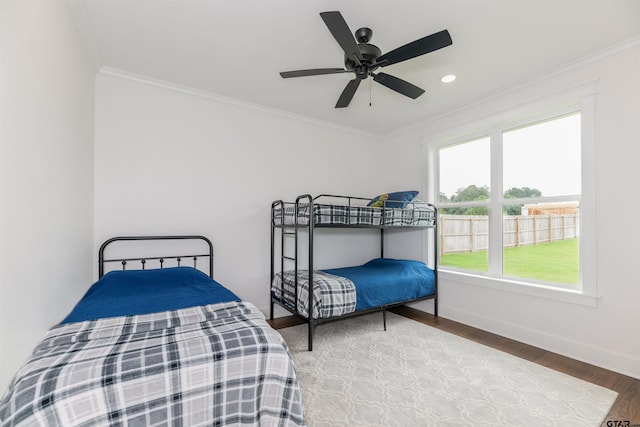 bedroom with hardwood / wood-style flooring, ceiling fan, and ornamental molding