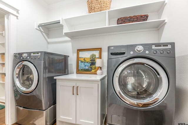 laundry area with cabinets, washer and clothes dryer, and ornamental molding