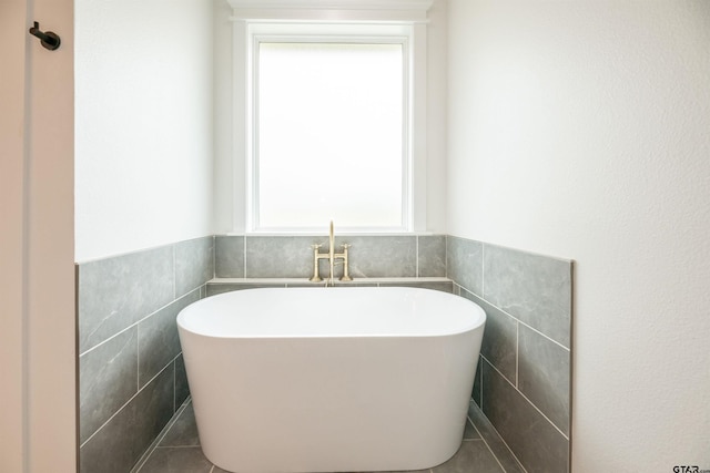 bathroom featuring a bathing tub and tile walls