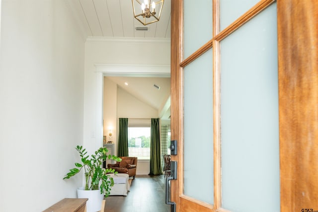 hall featuring hardwood / wood-style floors, lofted ceiling, ornamental molding, and a notable chandelier