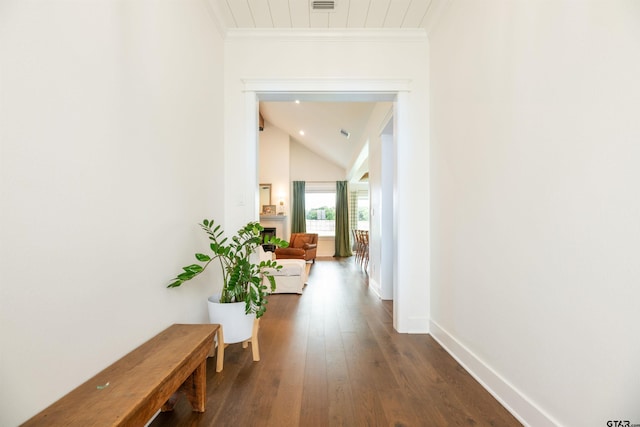 hallway featuring crown molding, dark wood-type flooring, and lofted ceiling