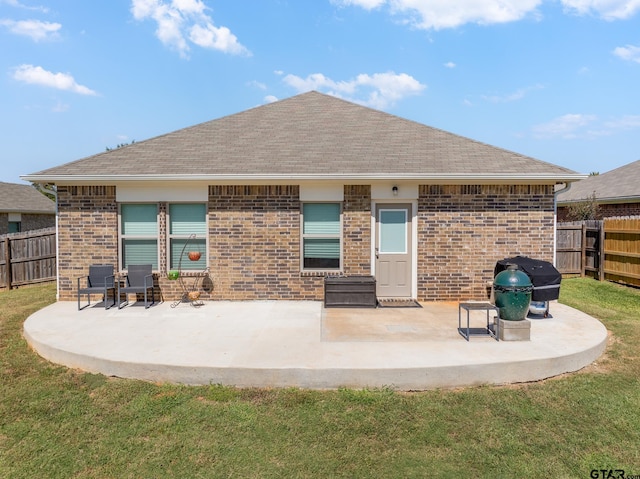 rear view of house with a patio and a yard