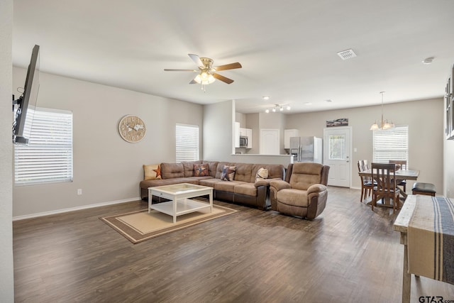 living room featuring dark hardwood / wood-style floors and ceiling fan with notable chandelier