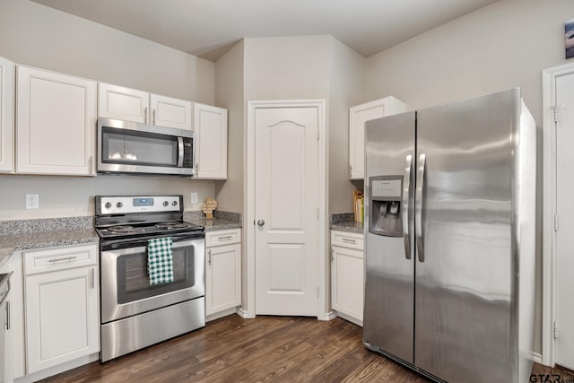 kitchen with white cabinets, dark hardwood / wood-style flooring, light stone countertops, and appliances with stainless steel finishes