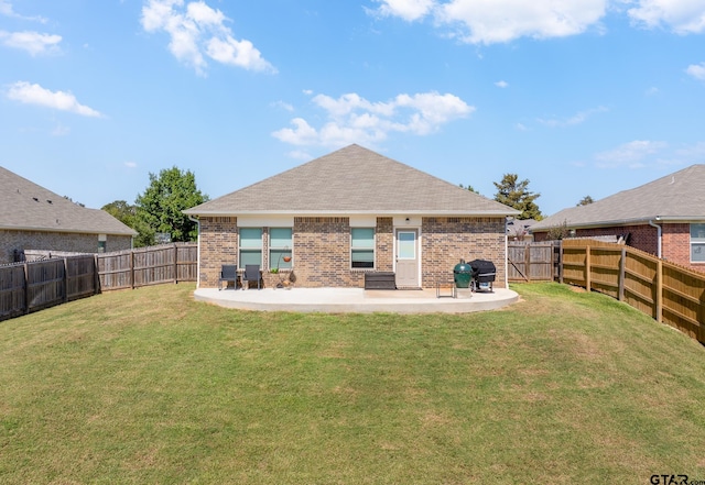 rear view of property featuring a yard and a patio area