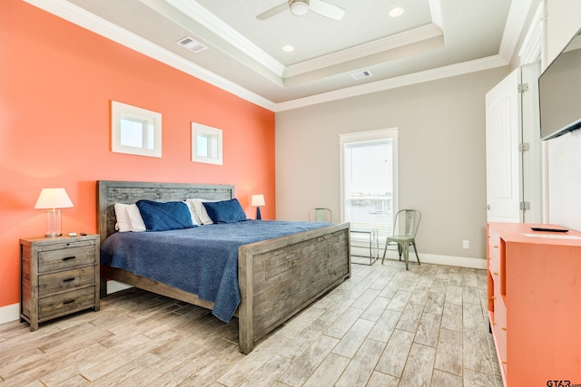 bedroom featuring crown molding, a tray ceiling, light hardwood / wood-style flooring, and ceiling fan