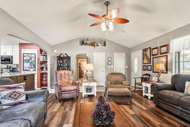 living room with visible vents, dark wood-type flooring, a ceiling fan, and vaulted ceiling