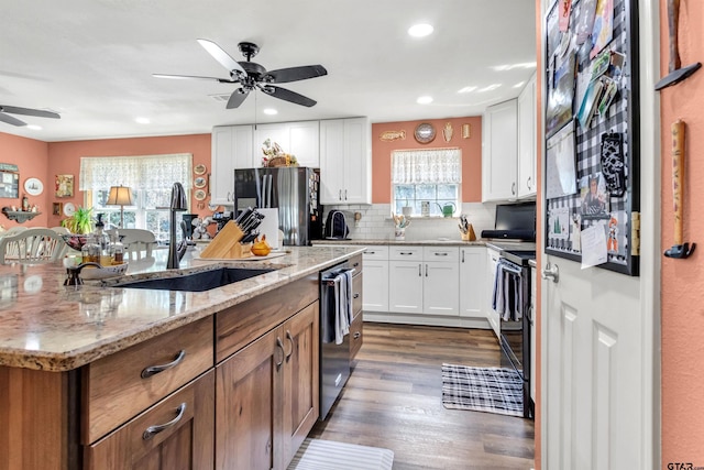 kitchen featuring stainless steel fridge with ice dispenser, dishwasher, decorative backsplash, white cabinetry, and a sink