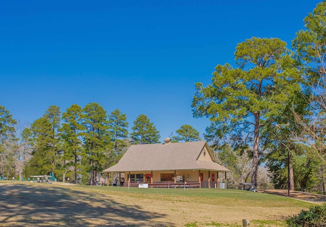 farmhouse featuring covered porch, a chimney, and a front lawn