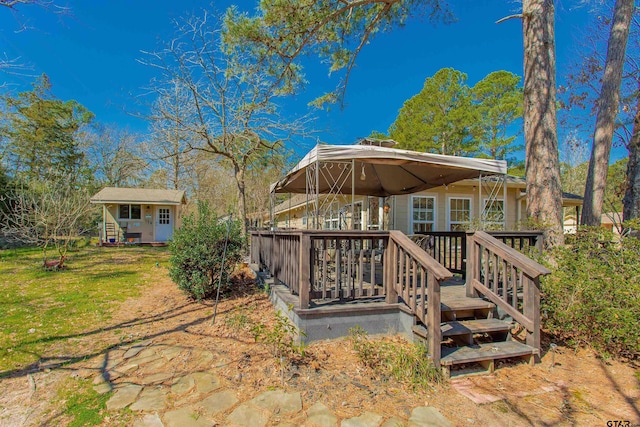 back of house with a gazebo, an outbuilding, and a lawn