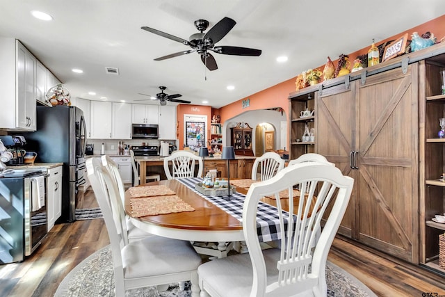 dining room with recessed lighting, visible vents, arched walkways, and dark wood-style floors