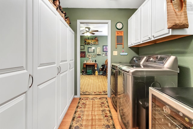 laundry room with light wood-type flooring, cabinet space, a ceiling fan, and washing machine and clothes dryer