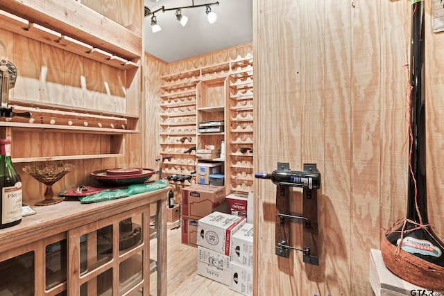 wine room with wood-type flooring and rail lighting