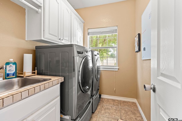 laundry room with cabinets, washer and dryer, and light tile patterned floors