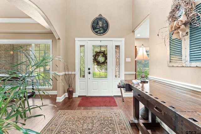 entrance foyer with ornamental molding and dark wood-type flooring