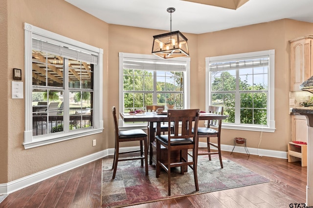 dining room featuring dark hardwood / wood-style floors and an inviting chandelier