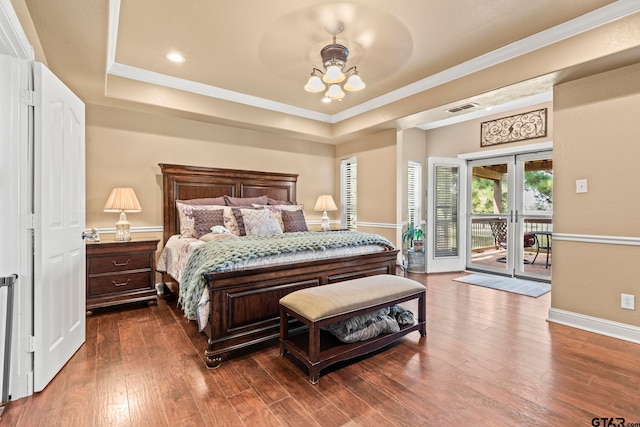 bedroom with access to exterior, wood-type flooring, a raised ceiling, and french doors