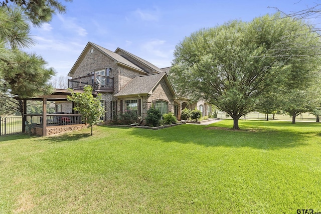 23120 Saddle Ridge Ct, Lindale, TX 75771 - back of house featuring a balcony, a lawn, and brick siding