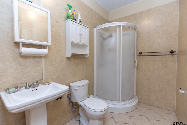 bathroom featuring tile patterned flooring, an enclosed shower, sink, and toilet