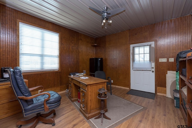 office space with light hardwood / wood-style flooring, ceiling fan, and wood walls