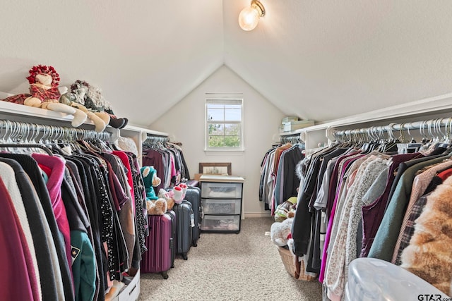 spacious closet with light colored carpet and vaulted ceiling