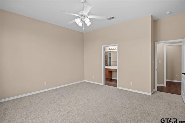 unfurnished bedroom with ceiling fan, light carpet, and connected bathroom