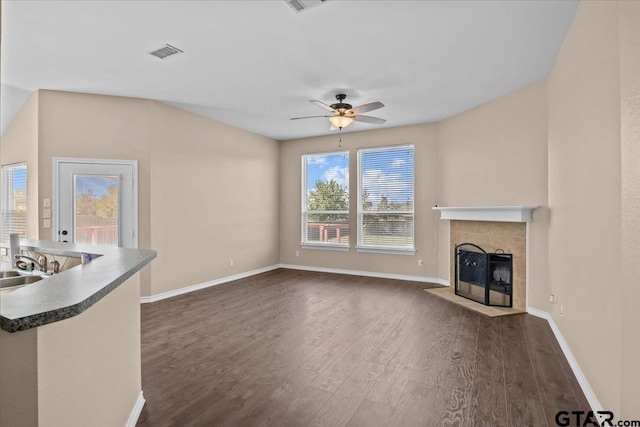 unfurnished living room featuring ceiling fan and dark wood-type flooring