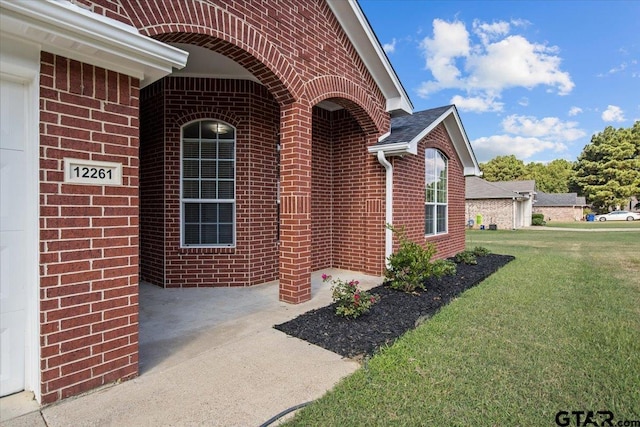 property entrance with a lawn