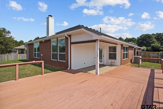 wooden deck with central air condition unit and a yard