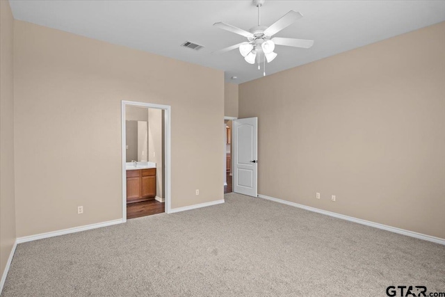 unfurnished bedroom featuring carpet flooring, ceiling fan, and ensuite bath