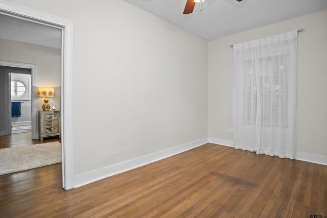 unfurnished room featuring baseboards, a ceiling fan, and wood finished floors