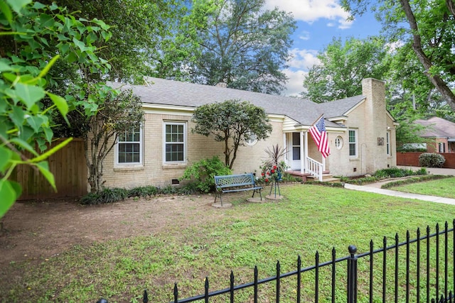view of front of property with crawl space, a chimney, a front lawn, a fenced backyard, and brick siding