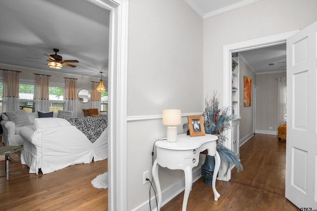 hallway with built in shelves, ornamental molding, baseboards, and wood finished floors