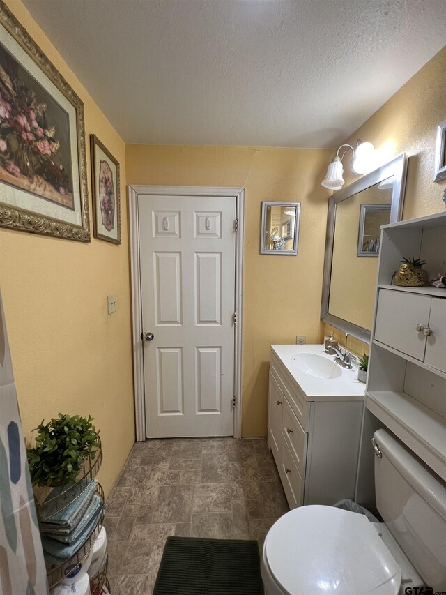 113 W Paschal St, Troup, TX 75789 - bathroom featuring vanity, a textured ceiling, and stone finish floors