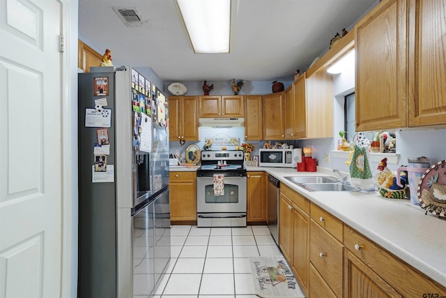 kitchen featuring stainless steel appliances, light tile patterned floors, and sink