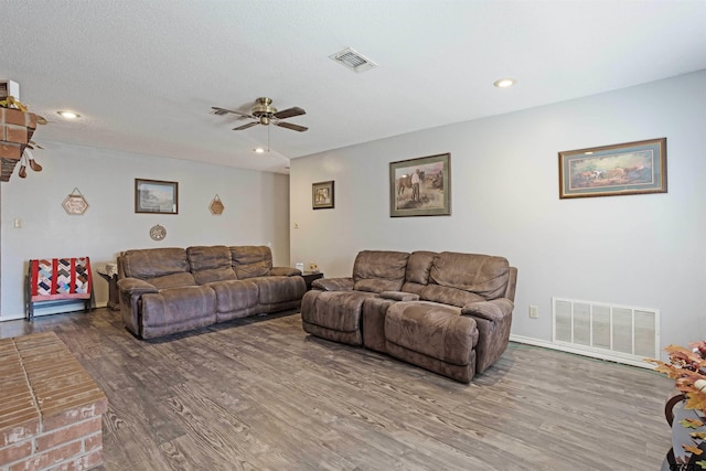 living room featuring a textured ceiling, hardwood / wood-style flooring, and ceiling fan