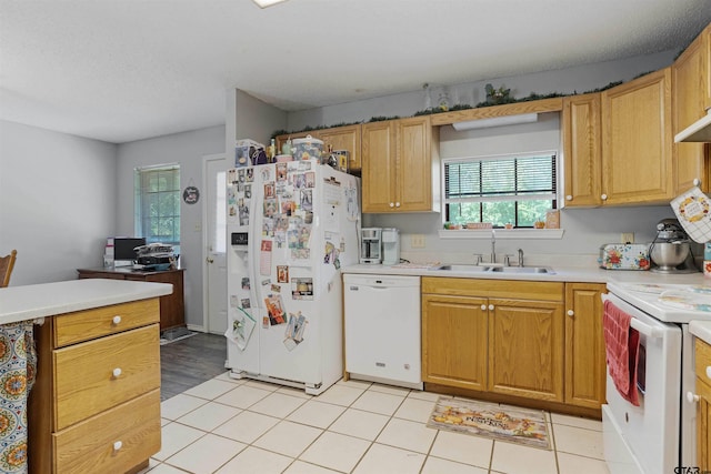 kitchen with light tile patterned floors, white appliances, and sink