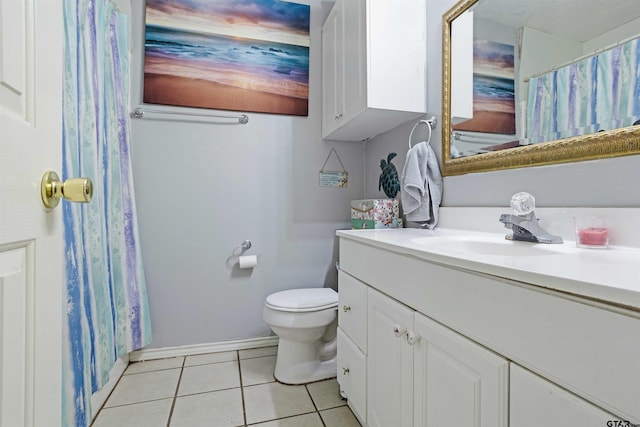 bathroom with toilet, vanity, and tile patterned floors