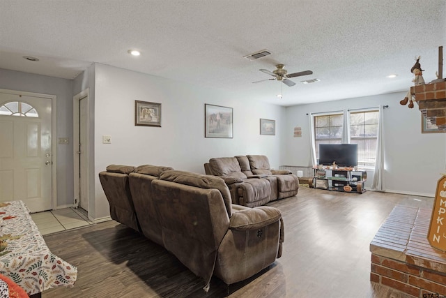 living room featuring hardwood / wood-style floors, a textured ceiling, and ceiling fan